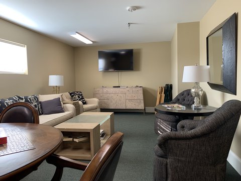 Activity Room with table, chairs, sofa and TV