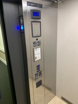 Inside of elevator showing buttons for floors and emergency contacts